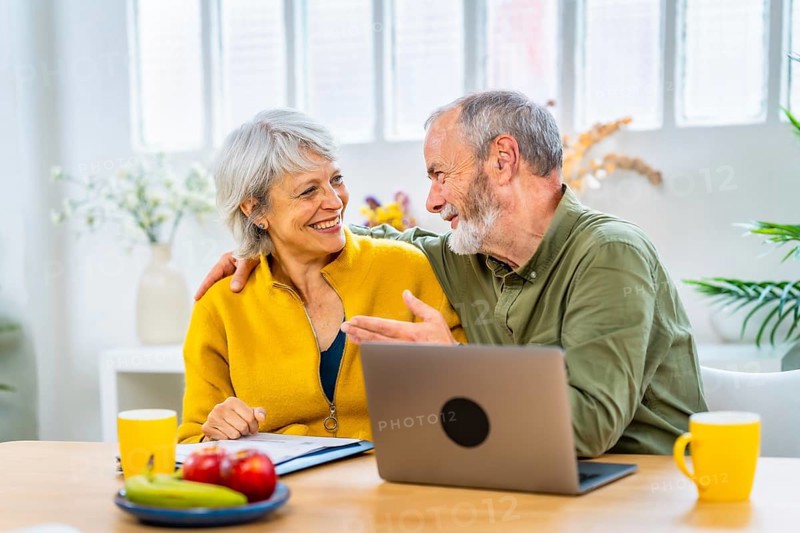 Happy senior woman receiving good news with online notification and her husband congratulate her