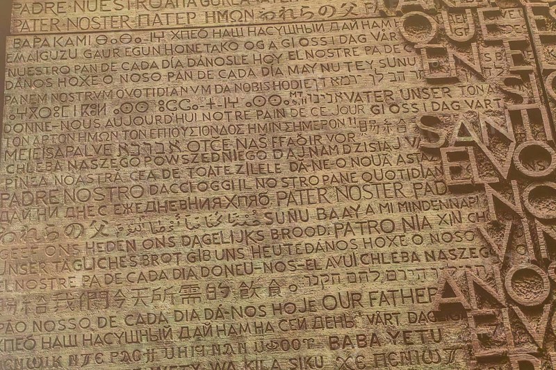 Lord's prayer written in many different languages, creating a spiritual and multicultural tapestry on a textured background