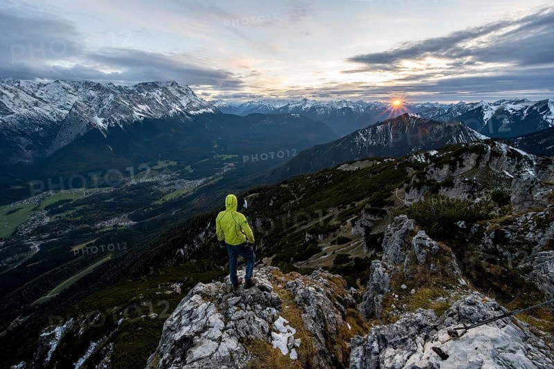 View Mountain panorama with Wetterstein mountains and Zugspitze, at sunset with sun star, mountaineer at the summit of the Kramerspitz, in autumn, Ammergau Alps, in autumn, Bavarian Prealps, Bavaria, Germany, Europe