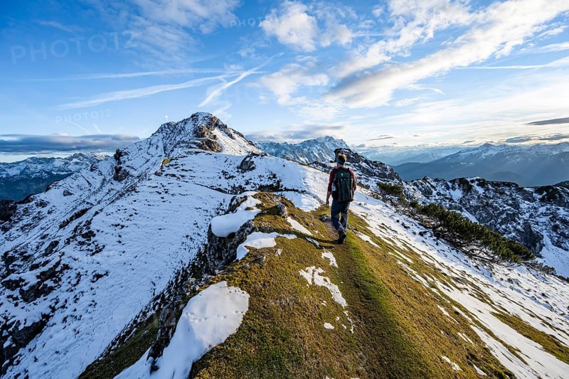 Mountaineer on hiking trail, mountain landscape with snow in autumn, summit and ridge of the Kramerspitz, Ammergau Alps, in autumn, Bavarian Alps, Bavaria, Germany, Europe