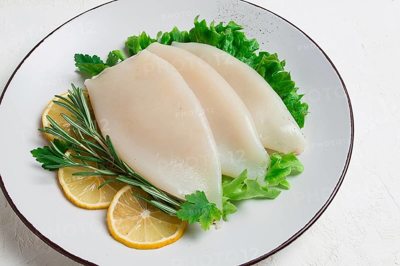 Fresh body, squid, raw, three carcasses, top view, no people, on a plate