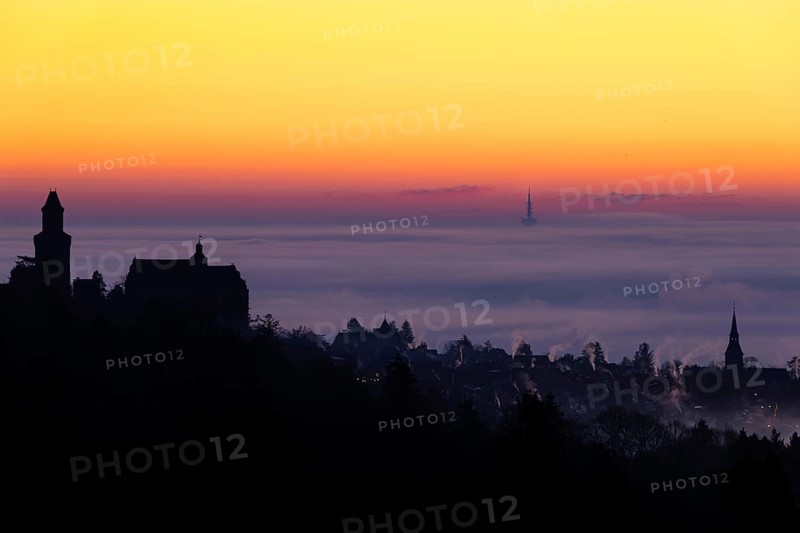 The silhouette of the town of Kronberg im Taunus stands out from the fog and cloud cover that envelops the Rhine-Main plain in the morning shortly in front of sunrise. Kronberg, Malerblick, Hesse, Germany, Europe