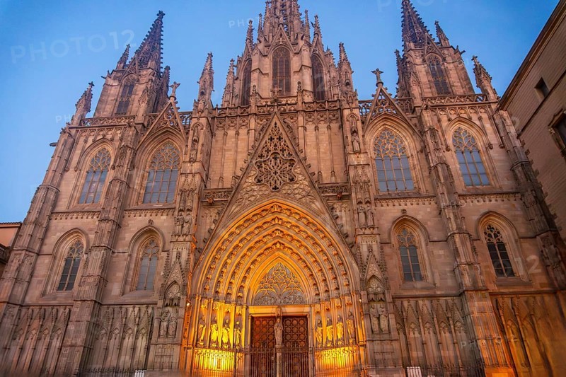 Warm lights illuminating the ornate facade of barcelona cathedral in the gothic quarter at dusk, showcasing its intricate architectural details