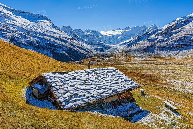 Alpine hut with snow-covered roof, slightly snow-covered alpine meadow, behind the Moiry glacier, near Grimentz, Val d'Anniviers, Valais Alps, Canton Valais, Switzerland, Europe