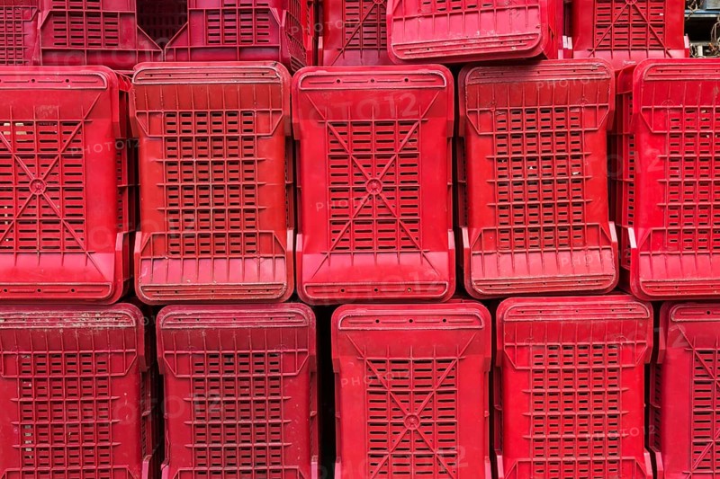 Rows of stacked red heavy duty plastic crates for transporting fruit and vegetables to processing plant, Sorrento, Campania region, Italy, Europe