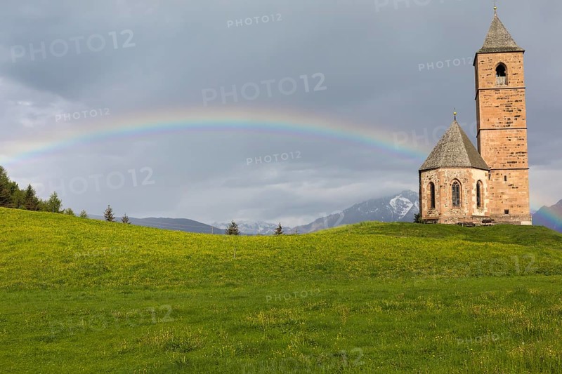 Church St. Kathrein, 39010 Hafling, Italy with a rainbow in the background. The church is from the 13 th century