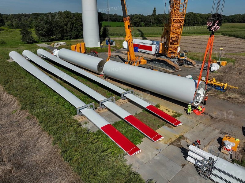 Dorsten, North Rhine-Westphalia, Germany, construction of a wind turbine, the first wind turbine of the Grosse Heide wind farm. The rotor blades are ready for assembly. A large mobile crane places the tower elements, the rings, on top of each other. This wind turbine will have a rated output of 5, 500 kW, Europe