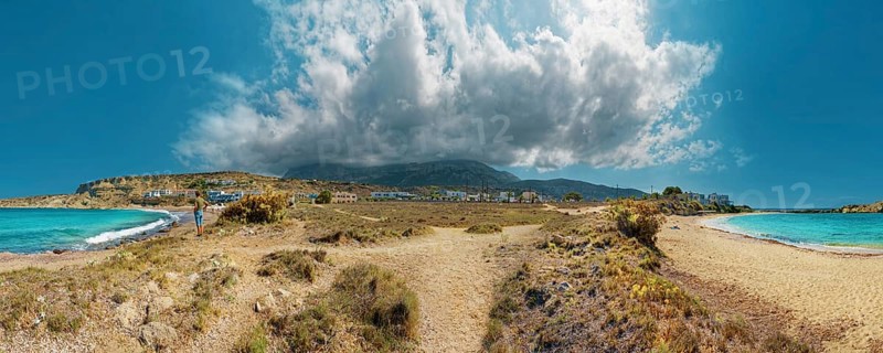 Wide Frangolimiona sandy beach with views of the blue sea, dramatic clouds and a vast coastal landscape, Arkasa, Karpathos, Greece, Europe