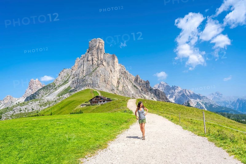 Female tourist enjoying hiking on a sunny summer day at the scenic giau pass in the italian dolomites