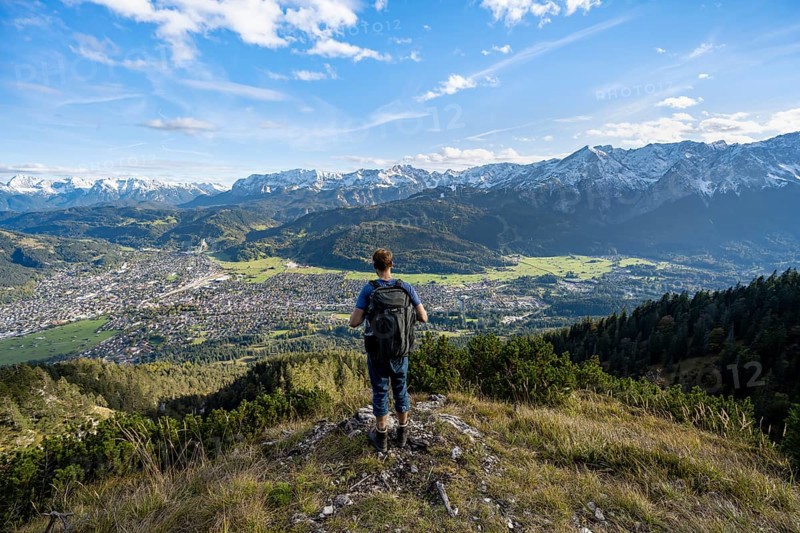 View of Garmisch-Partenkirchen and mountain panorama, mountaineer on hiking trail to Kramerspitz, in autumn, Ammergau Alps, in autumn, Bavarian Prealps, Bavaria, Germany, Europe