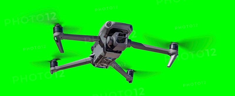 Isolated unmanned aircraft system (UAV) quadcopter drone in the air over A green screen