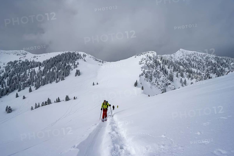 Ski tourers on the ascent to Raukopf, mountain landscape in the snow, mountain peaks Tanzeck and Aiplspitz, dramatic clouds, Mangfallgebrige, Bavaria, Germany, Europe