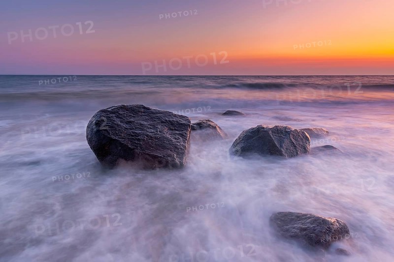 Large boulders in surf at Brodtener Ufer, Brodten Steilufer, cliff in the Bay of Lübeck along the Baltic Sea at sunrise, Schleswig-Holstein, Germany, Europe