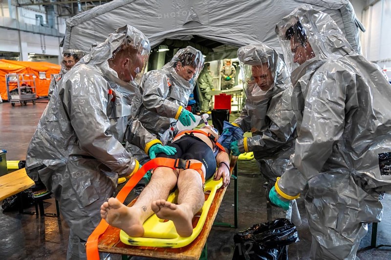 Decontamination of injured persons after an assumed accident involving hazardous substances, fire brigade and aid organisations practise setting up and operating a decontamination station, injured persons are sighted and then washed in a special shower tent to remove possible hazardous substances and chemicals in order to avoid further injuries, the emergency services wear special, ventilated protective suits, large-scale exercise by the Essen fire brigade