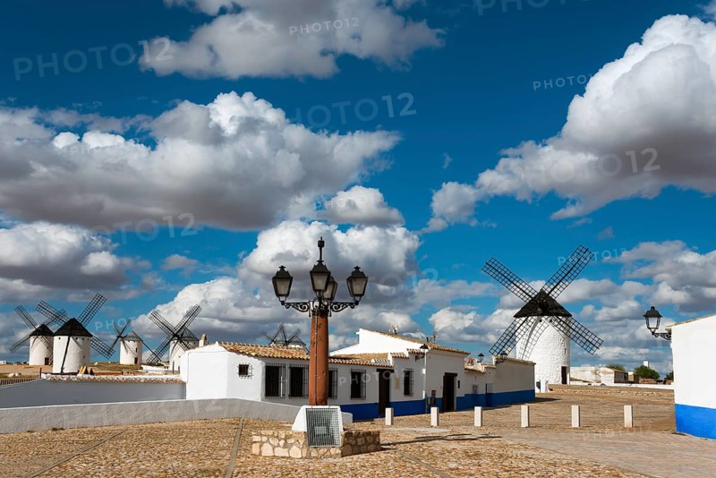 Windmills and street lamp in a charming village under a blue sky with clouds, windmills and village, Campo de Criptana, Ciudad Real province, Castilla-La Mancha, Route of Don Quixote, Spain, Europe