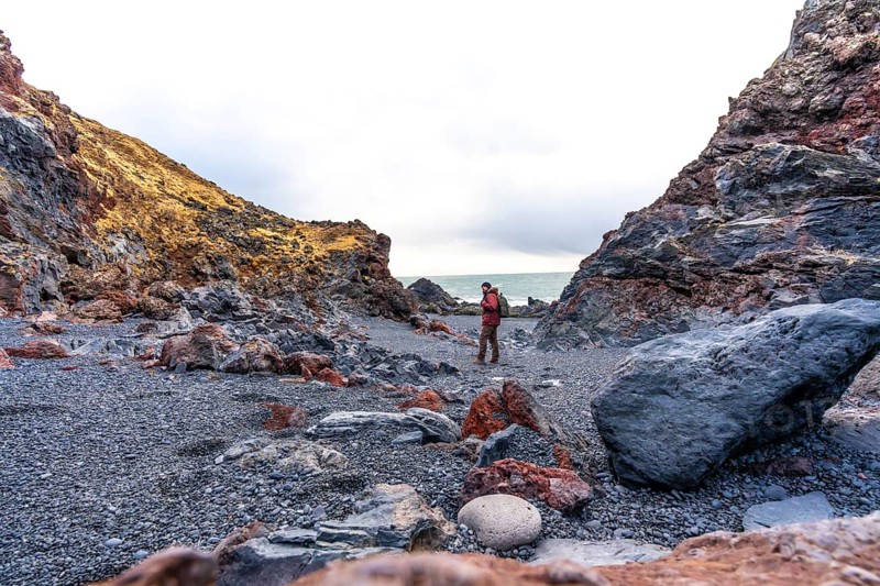 A tourist man on Djupalonssandur beach on the Snaefellsnes peninsula in winter in Iceland