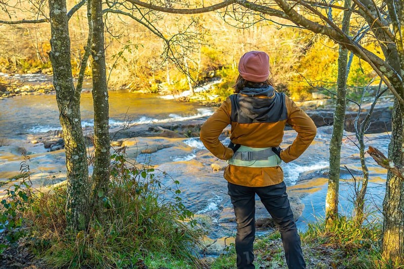 Female hiker enjoying the view of the baias river in the gorbeia natural park on a sunny autumn day