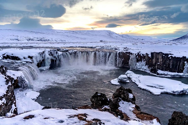 Beautiful landscape at frozen Godafoss waterfall at sunset in winter, Iceland, Europe