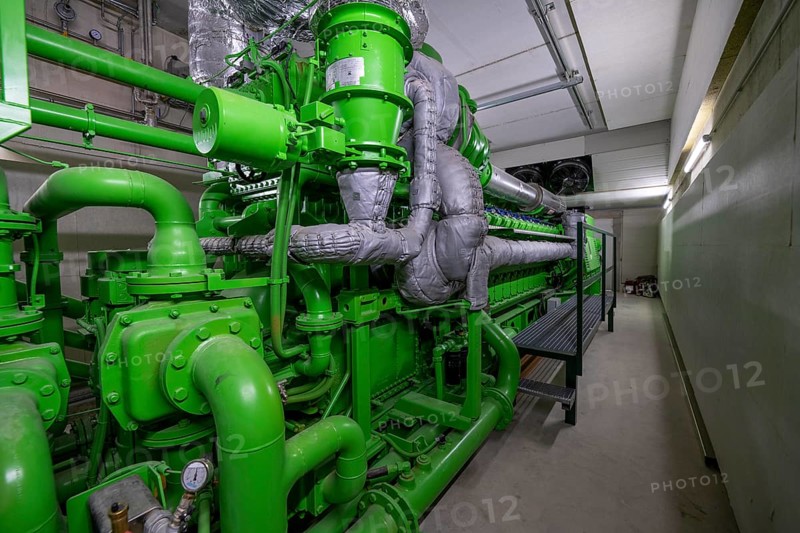Biogas plant, gas-powered engine for electricity production, generator, in combined heat and power plant, the gas is produced from various biomass, including waste from the food industry, the electricity is produced in combined heat and power plants with the biogas produced and fed into the grid, the heat is sent to 70 households via a local heating network, part of the gas is processed and fed into the Thyssengas gas network, Anröchte, North Rhine-Westphalia, Germany, Europe