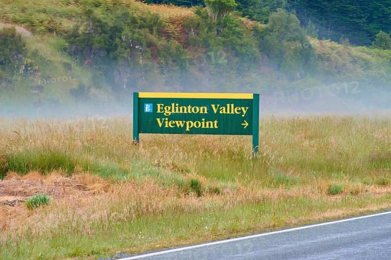 Sign showing the way to Eglinton Valley viewpoint, surrounded by misty pasture, summer, Milford Sound, Te Anau, Fiordland National Park, South Island, New Zealand, Oceania