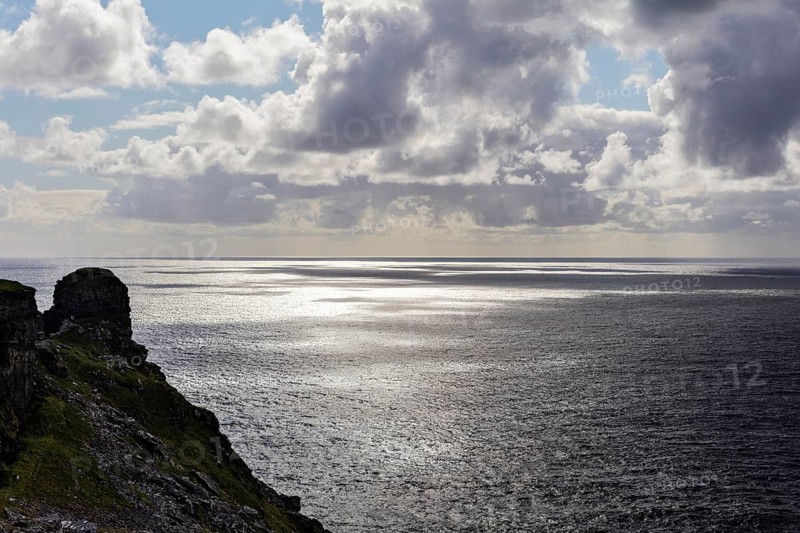 Rocky coast with a view of the sea under dramatic clouds, Cliffs of Moher