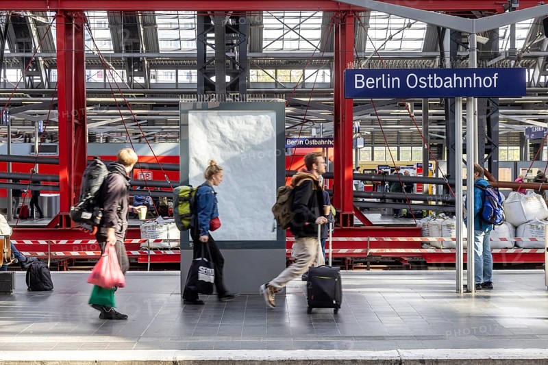 Construction site at Ostbahnhof station with station sign, travellers on the platform. Berlin, Germany, Europe