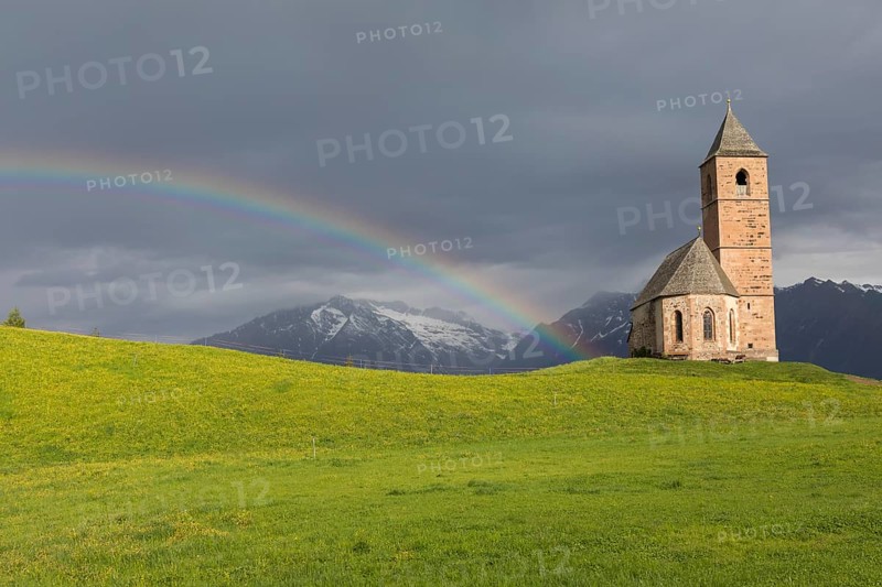 Church St. Kathrein, 39010 Hafling, Italy with a rainbow in the background. The church is from the 13 th century