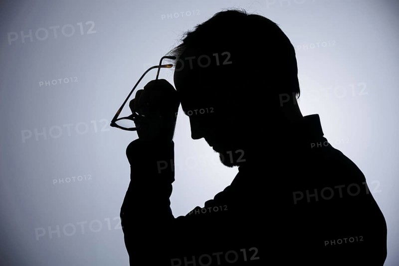 Symbolic photo on the subject of overload. Silhouette of a man rubbing his aching head. Berlin, 22/08/2024
