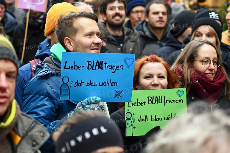 Heidelberg, Germany - February 12th 2025: Person holding up sign saying 'I'd rather wear blue than vote blue' in crowd at protest against far-right