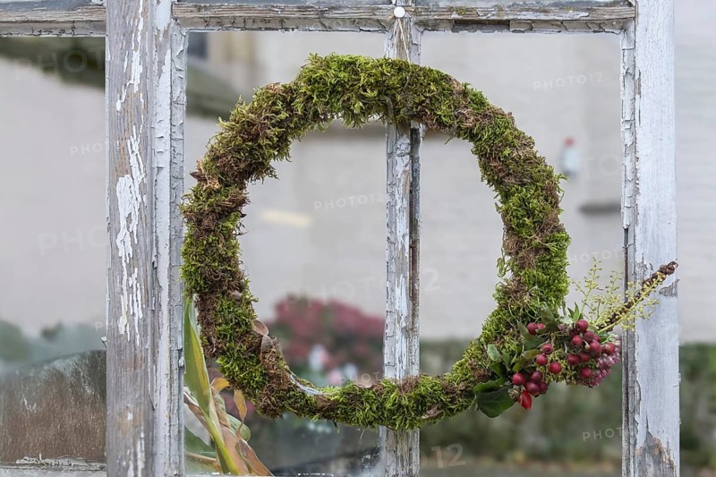 Door or window wreath made of natural materials in front of an old window, decoration, North Rhine-Westphalia, Germany, Europe