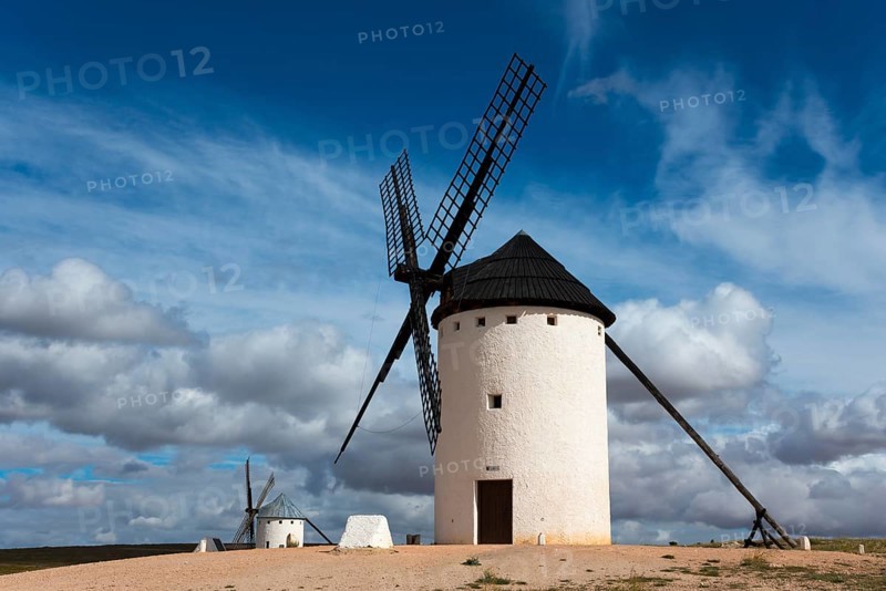 White windmill under a dramatic sky with other mills in the background, Campo de Criptana, Ciudad Real province, Castilla-La Mancha, Don Quixote Route, Spain, Europe