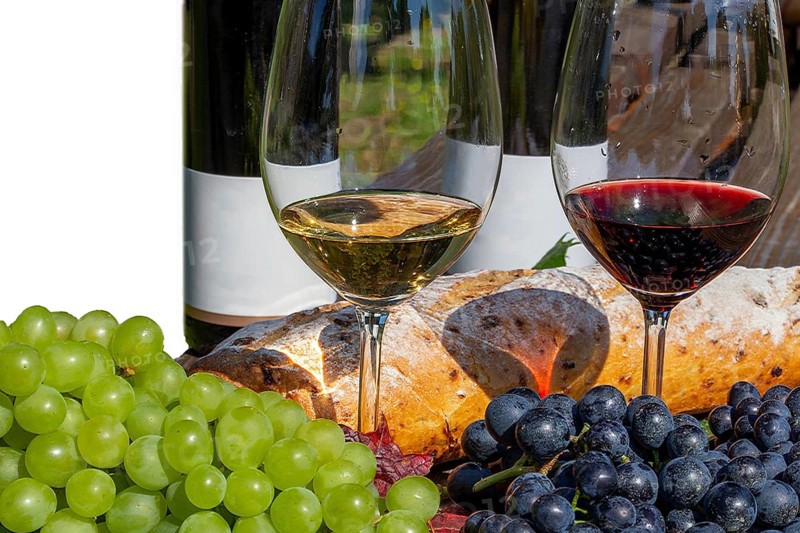 Symbolic image of grape grape harvest: Ripe grapes decorated with wine glasses on a wooden table