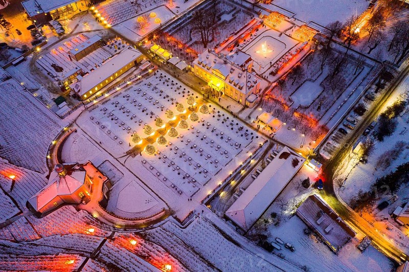 Aerial view of Wackerbarth Castle with castle park, belvedere and vineyards with snow and Christmas lights, Radebeul, Saxony, Germany, Europe