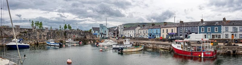 Small harbour with boats and surrounding buildings under a grey sky, Ballycastle