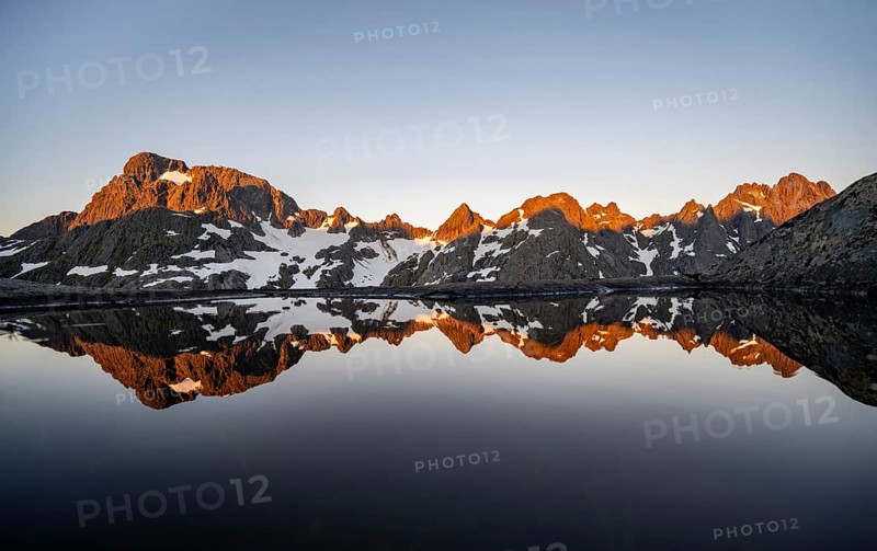 Rocky mountain peaks reflected in a small pond, mountain landscape with alpenglow at sunrise, at the Trollfjord Hytta, at the Trollfjord, Lofoten and Vesterålen, Nordland, Norway, Europe