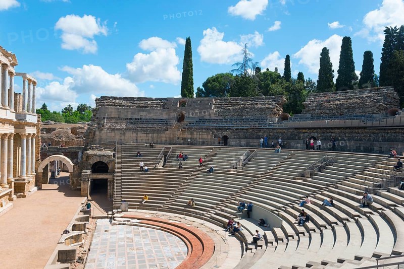An ancient amphitheatre with stone seats under a blue sky with clouds and trees in the background, Teatro Romano de Mérida, Roman theatre of Merida, Merida, Badajoz, Extremadura, Spain, UNESCO World Heritage Site, Europe
