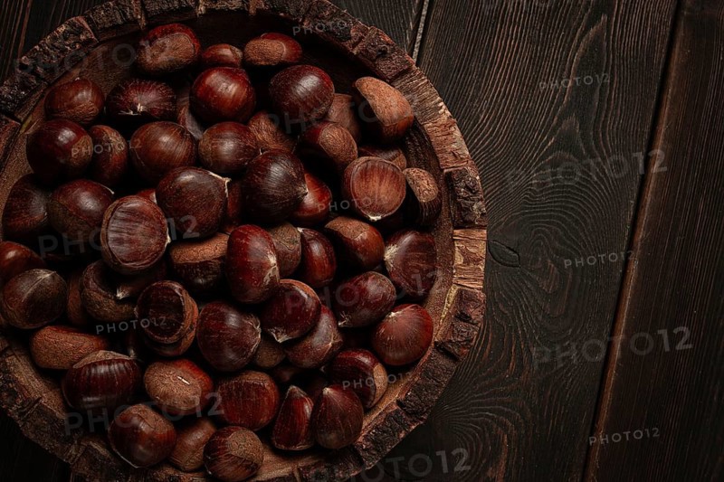 Fresh chestnuts, in a wooden bowl, top view, no people