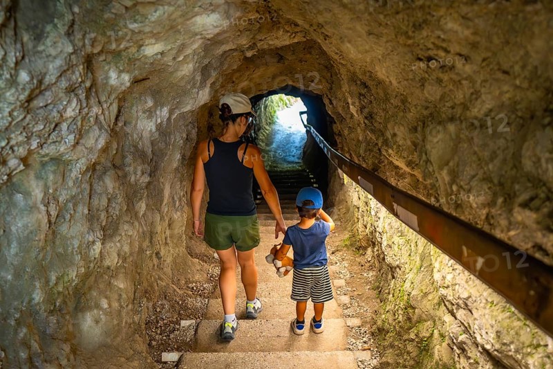 Mother and son walking through a tunnel in tolmin gorge, a popular tourist destination in slovenia