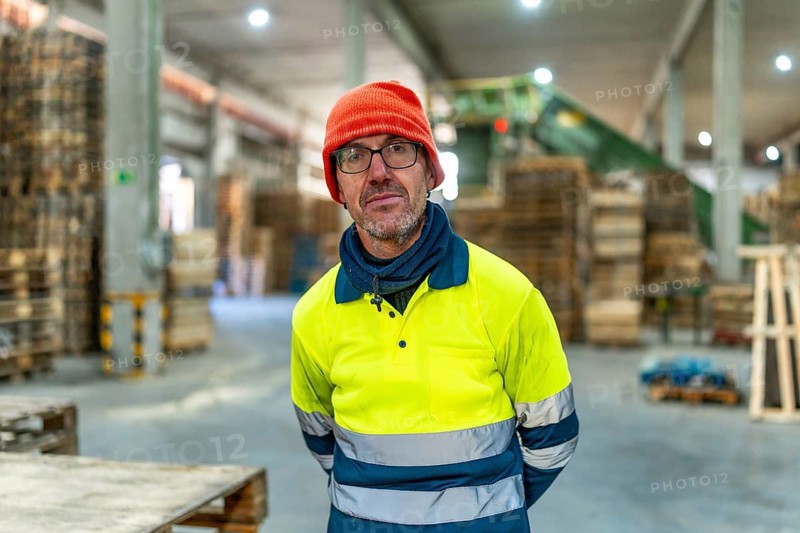 Portrait of a adult serious caucasian man carpenter standing working in a recycling plant
