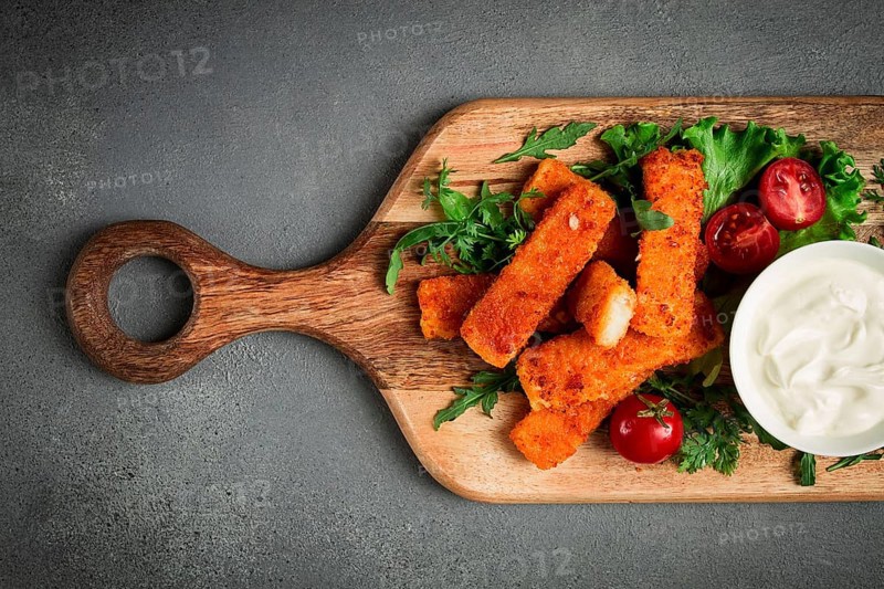 Fried fish nuggets, with white sauce, arugula and cherry, no people