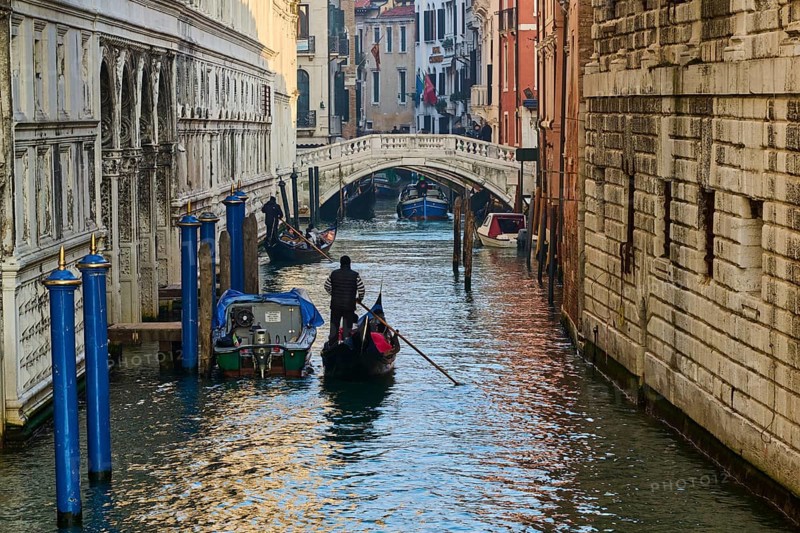 View from 'Ponte della paglia' over a waterway on a sunny morning with gondolier in Venice on a foggy morning in winter, Italy, Europe