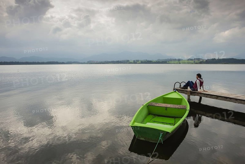 Woman 50-60, wooden jetty, green rowing boat, Hopfensee, Hopfen am See, near Füssen, Ostallgäu, Allgäu, Bavaria, Germany, Europe