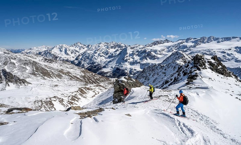 Ski tourers descending from the summit of the Madritschspitze, mountain panorama with snow-covered mountain landscape in winter, Ortler Alps, Vinschgau Valley, Italy, Europe