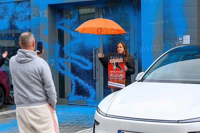 Angry man takes photo of New Generation's Judith Beadle after colour attack on Tesla store. You should be smashed. Tesla Centre in Berlin Reinickendorf, 31.03.2025