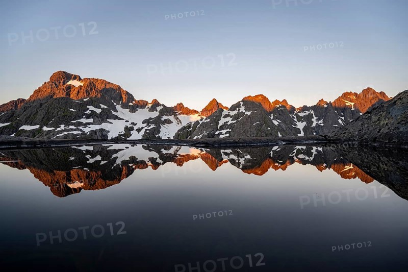 Rocky mountain peaks reflected in a small pond, mountain landscape with alpenglow at sunrise, at the Trollfjord Hytta, at the Trollfjord, Lofoten and Vesterålen, Nordland, Norway, Europe
