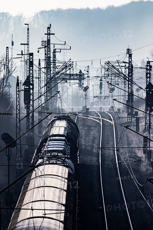 Deutsche Bahn AG tracks backlit with goods train. Overhead line, signals and infrastructure. Railway tracks at the Geislinger Steige, Alb ascent to the Swabian Alb. Amstetten, Baden-Württemberg, Germany, Europe