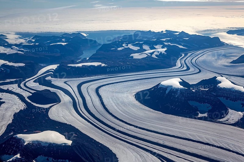 Aerial view of glaciers, glacier tongues and icy mountains on the coast, sunny, East Greenland, Greenland, North America