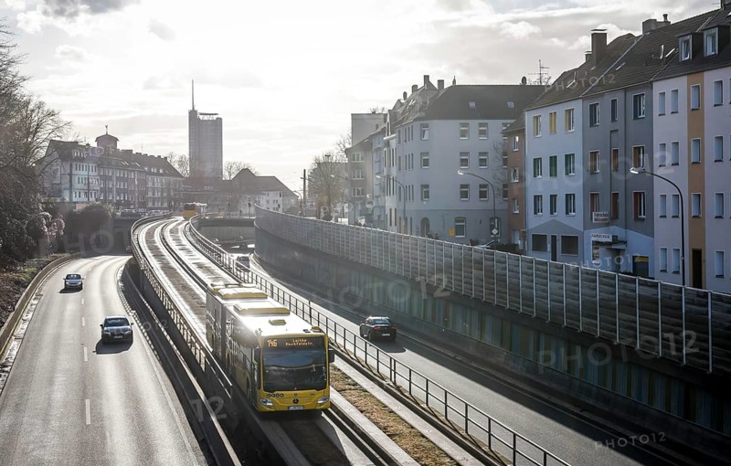 Essen, North Rhine-Westphalia, Germany - Cars and a public bus drive on the A40 motorway through the city centre of Essen, behind the Westenergie Tower, former RWE Tower