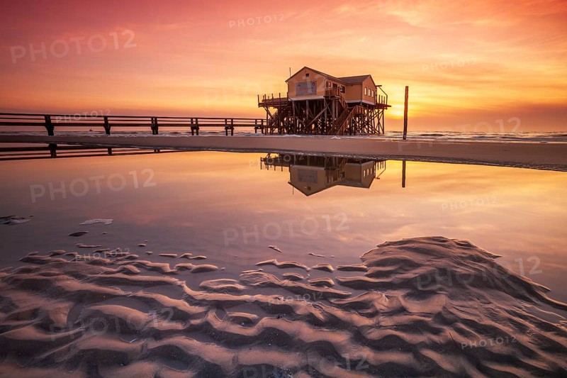 Stilt house on the beach at sunset, reflection in tidal pool, St. Peter-Ording Schleswig-Holstein Wadden Sea National Park, Schleswig-Holstein, Germany, Europe