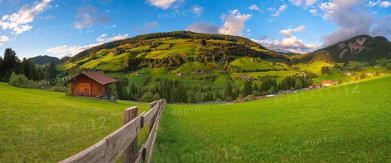 View along a wooden fence across a pasture to the mountains in the evening light, Dolomites, Odle Group, Sasso Putia Group, San Maddalena, Funes, Funes Valley, South Tyrol, Italy, Europe